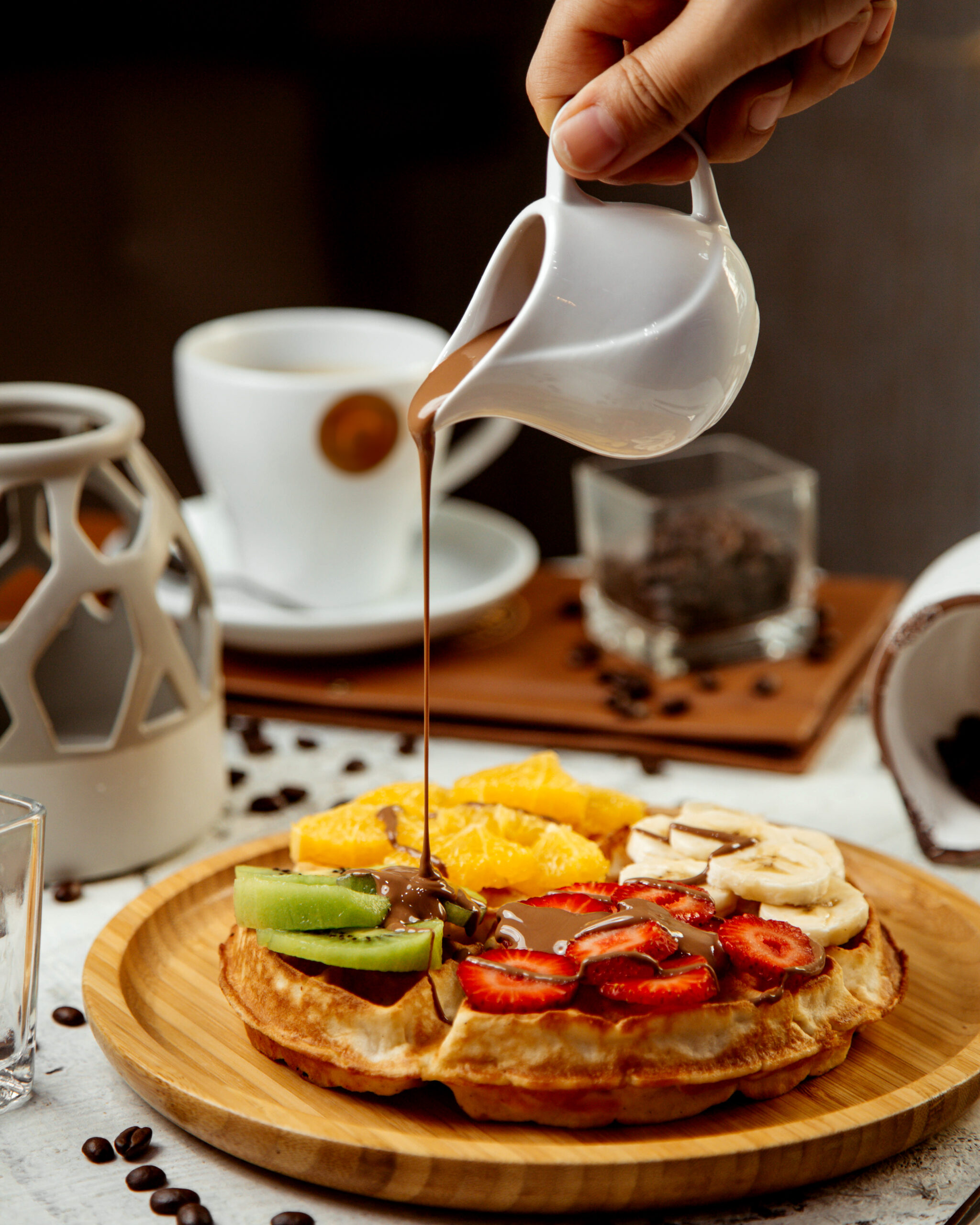 waffles topped with sliced fruits and hot chocolate